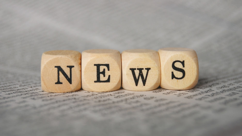 the word news on cubes on a newspaper | Vargiu Professional Services, Inc.